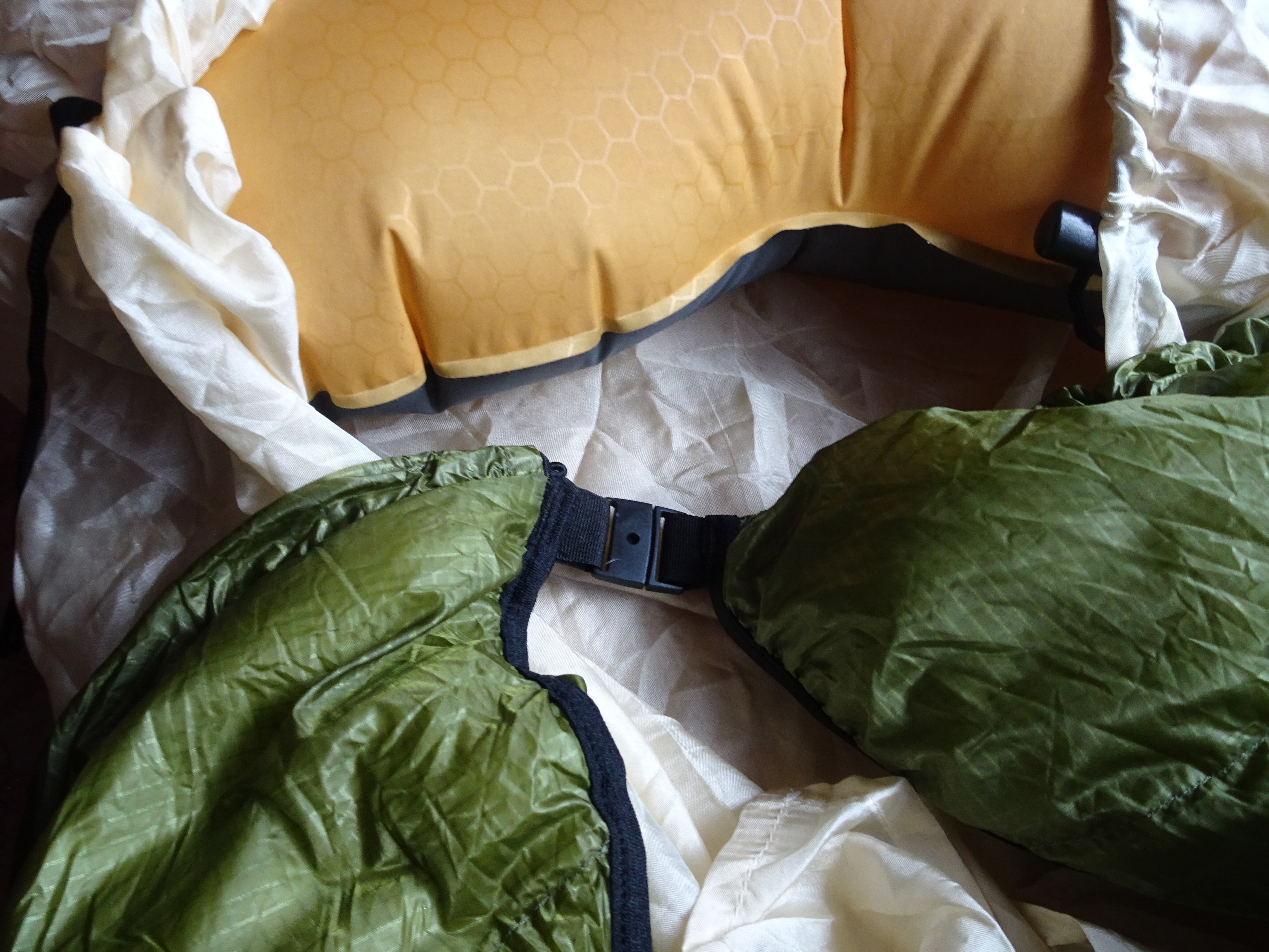 A small plastic buckle closes the quilt behind your neck. A similar system for the straps would be more convenient.